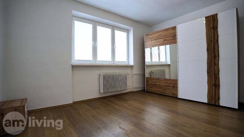 A room with a wooden floor design and a large wardrobe in a 3-room apartment.