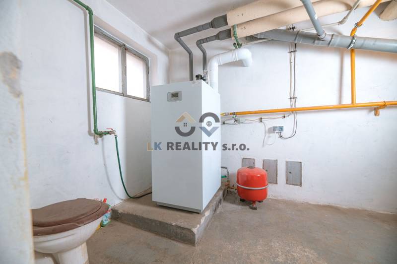 Technical room with a boiler and piping system in a family house.