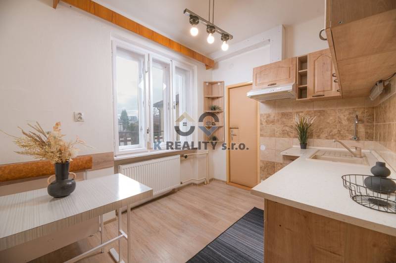 A family house kitchen with a wooden decor floor and light furniture.