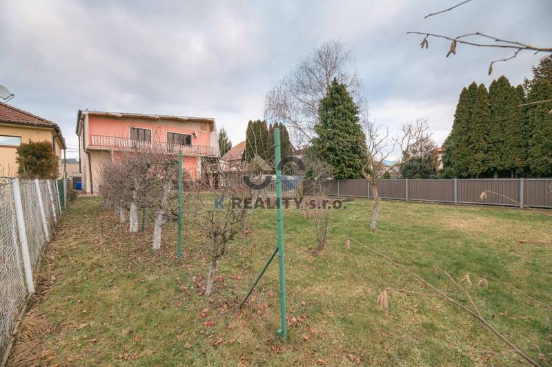 The garden of a family house on Kpt. Jaroša Street in Trenčín with fruit trees and grass.