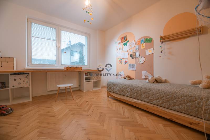 Children's room in a 3-room apartment with a bed, table, and floor with a wooden decor.