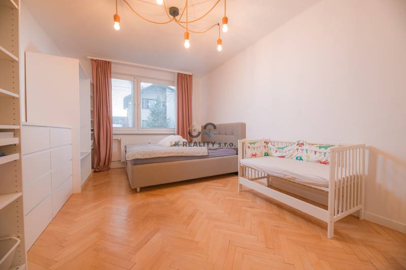 Children's room in a 3-room apartment with a wooden decor floor, a bed, and a crib.