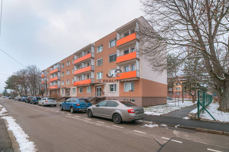 Apartment building on Bezručova Street in Trenčín with parked cars and snowy surroundings.