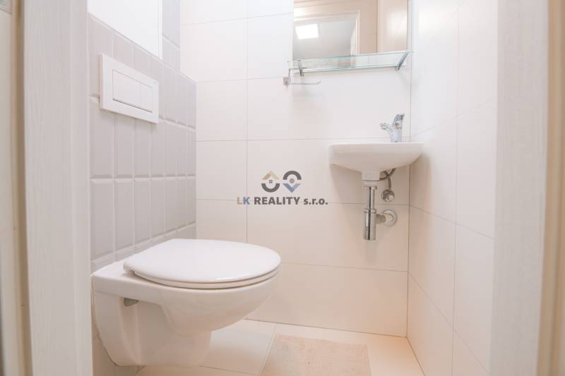 Bathroom in a 3-room apartment with white tiles and a wall-hung toilet.