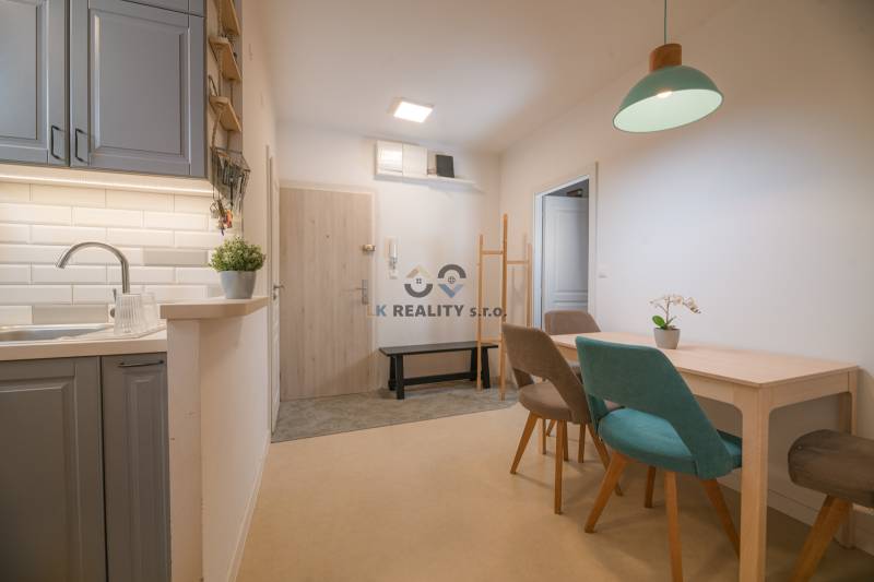 Kitchen and dining area in a 3-room apartment with a wooden decor floor.