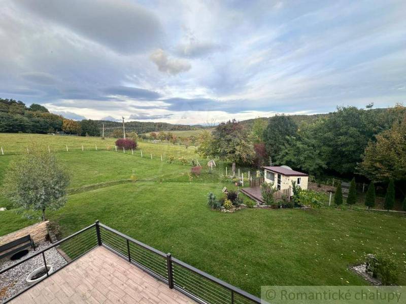 View from a family house in Lukovištia to a garden with a gazebo, lawn, and trees.