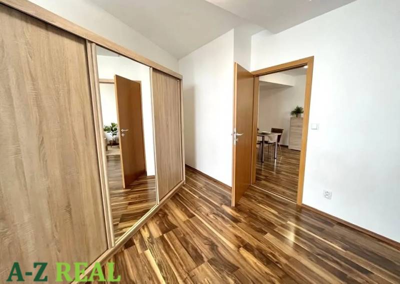 Interior of a 3-room apartment with a wooden decor floor and a built-in wardrobe.
