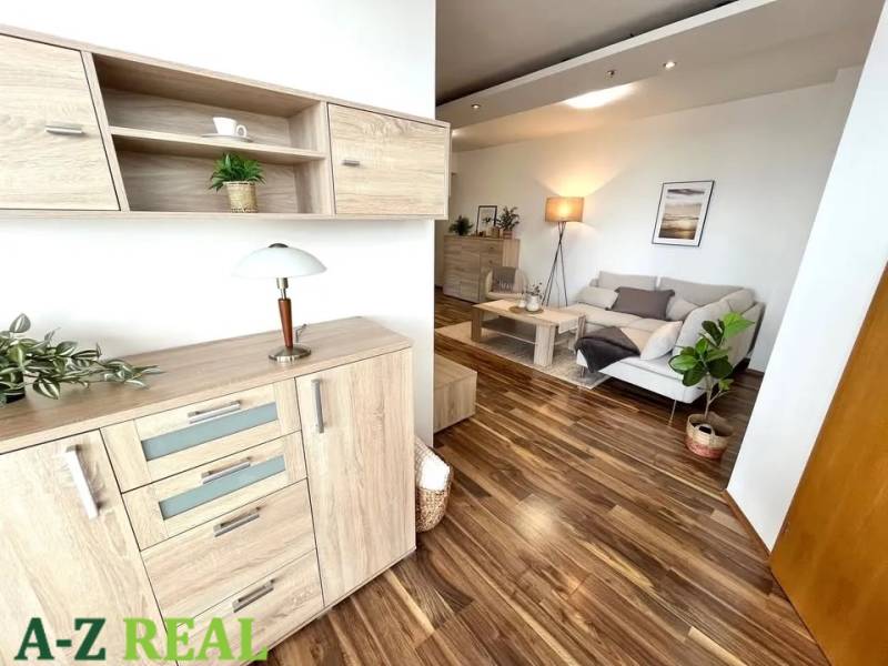 Interior of a 3-room apartment with a wooden decor floor and light furniture.