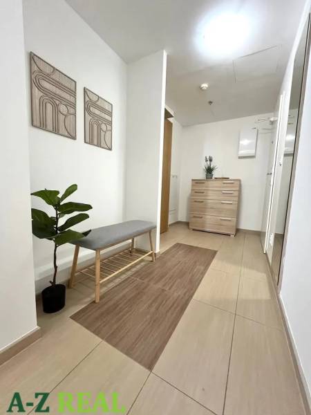 Interior of a 3-room apartment with light furniture, a bench, and decorative paintings.