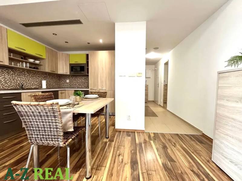 A kitchen in a 3-room apartment with a dining table and a wooden decor floor.