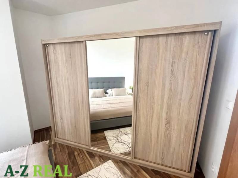 Mirrored wardrobe in the bedroom, 3-room apartment, floor with wood decor.