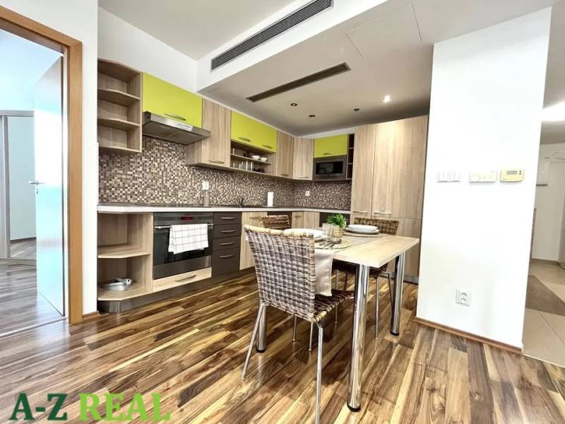 A kitchen in a 3-room apartment with mosaic tiles and a wooden decor floor.