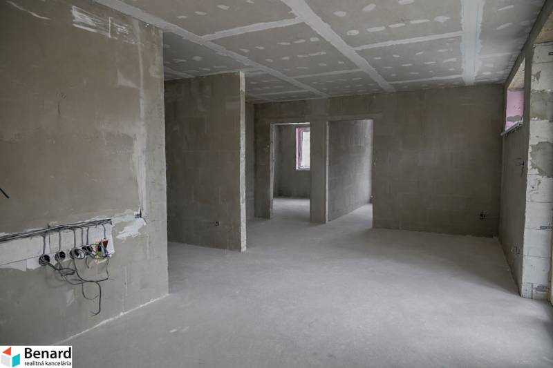 Unfurnished interior in a 3-room apartment with raw walls and preparations for electrical installations.