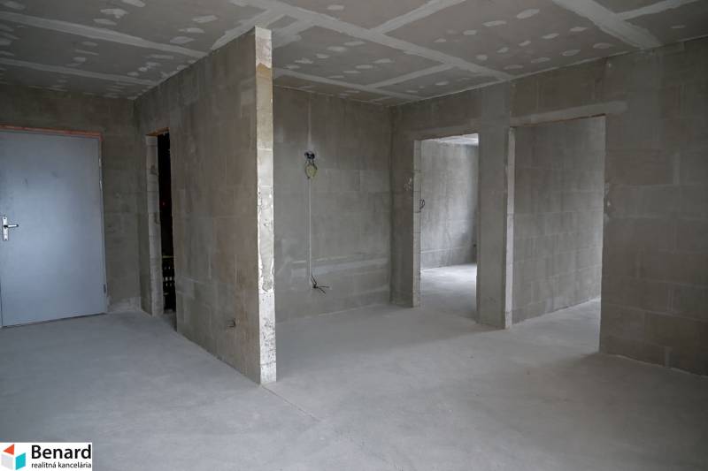 Unplastered walls and a concrete floor in a 3-room apartment.