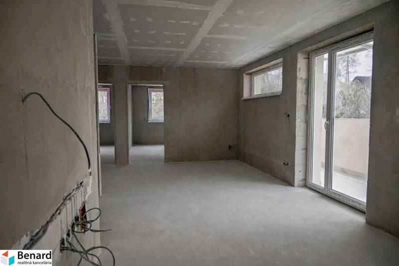 Unfinished space of a 3-room apartment with unplastered walls and large windows.