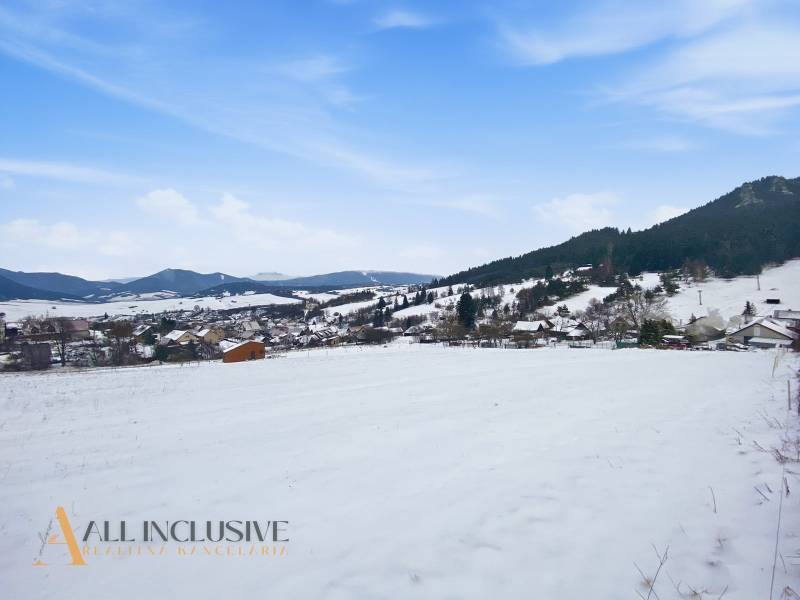 Snow-covered residential plots in Komjatná with views of the mountains and the village.