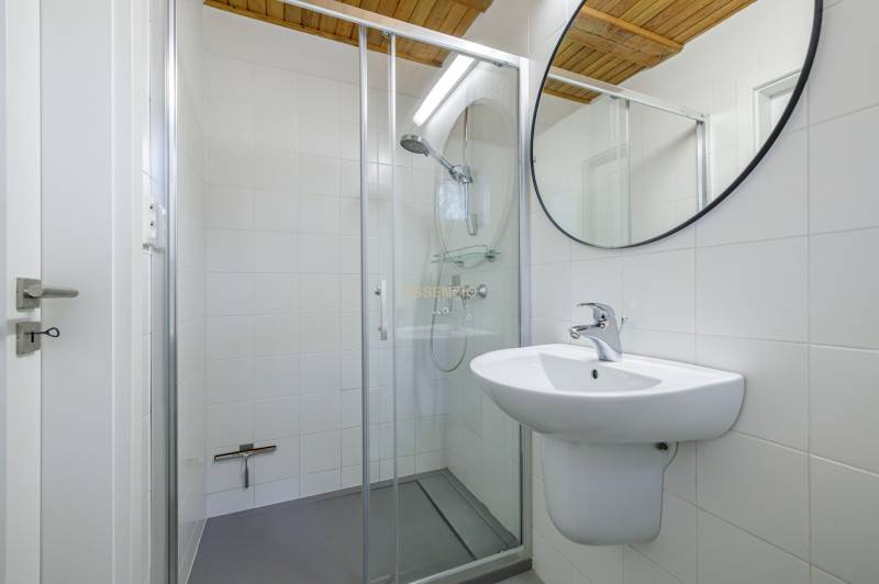 Bathroom with a sink, mirror, and shower in a family house.