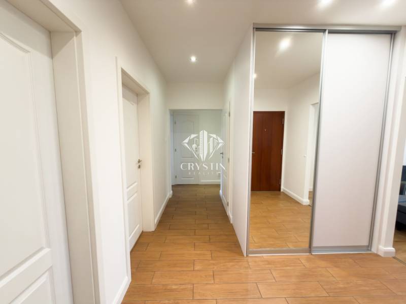 A hallway with a built-in wardrobe and a wooden decor floor in a 4-room apartment.