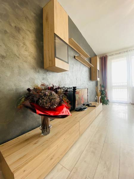 Living room with wood-patterned flooring and stylish furniture in a 3-room apartment.