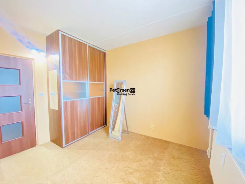 A room in a 3-room apartment with a sliding wardrobe and a beige carpet.