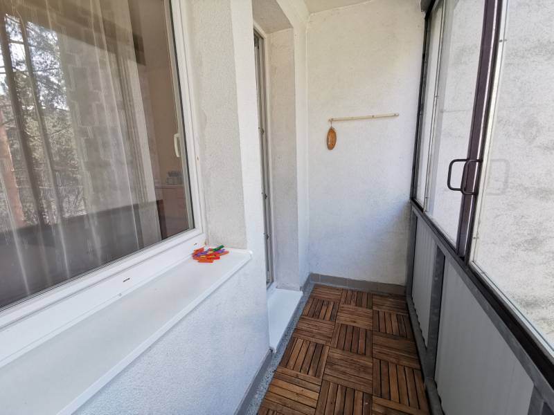 Glazed balcony in a 2-room apartment with a wooden decor floor.