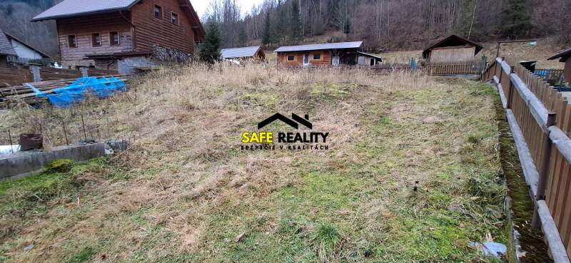 A plot for residential use in Oščadnica surrounded by wooden structures and forest.