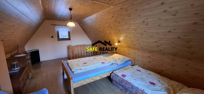 A room in a cabin with wooden decor, two beds, and a window, ideal for relaxation.