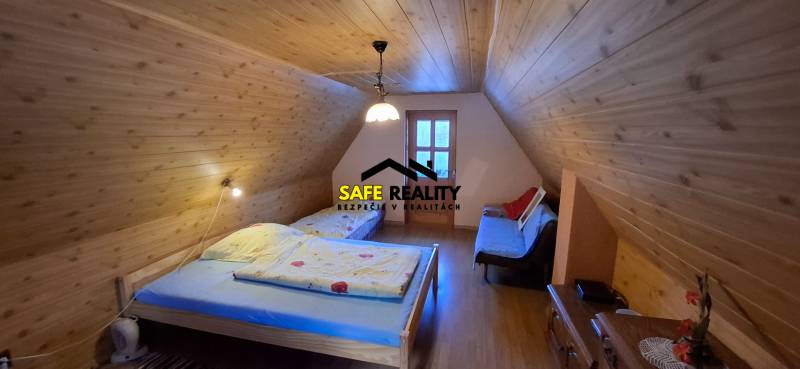 Wooden interior of a cabin with a bed and a floor with a wooden design.