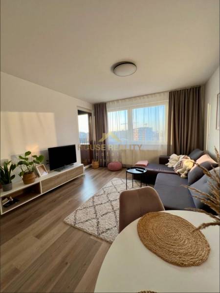 Living room with a sofa, television, and floor with wood decor in a 2-room apartment.