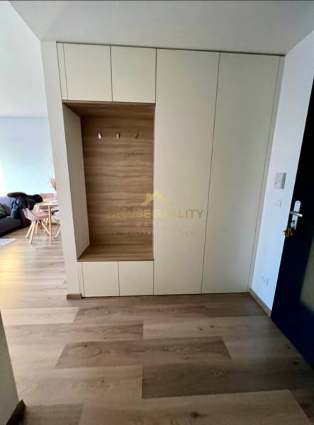 Entrance hallway with storage space and wooden decor flooring in a 2-room apartment.