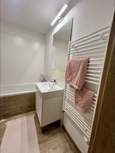 Bathroom with a bathtub and a sink, floor with wooden decor, 2-room apartment.