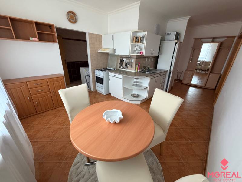 Kitchen corner with seating in a 3-room apartment, with a wooden decor floor.