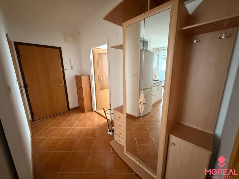 Hallway in a 3-room apartment with tiles, a coat rack, and a built-in wardrobe with a mirror.