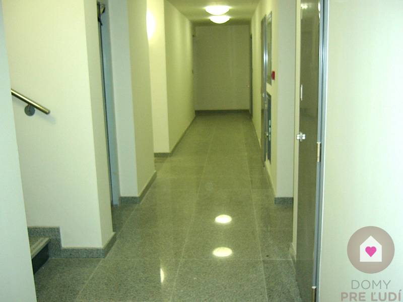 A corridor in offices with tiled floor and white walls.