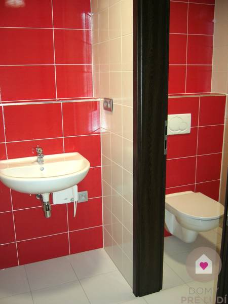 Bathroom with a white sink and toilet, red and white tiles. Offices.