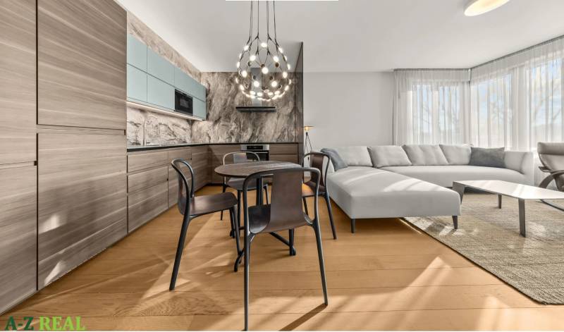 Kitchen and living room in a 2-room apartment with a wooden decor floor and a comfortable sofa.