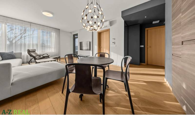 Interior of a 2-room apartment with a wooden decor floor, a round table, and lighting.