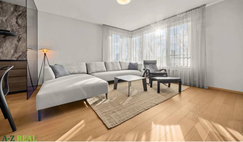 Living room with wood-patterned flooring, white sofa, and large windows in a two-room apartment.