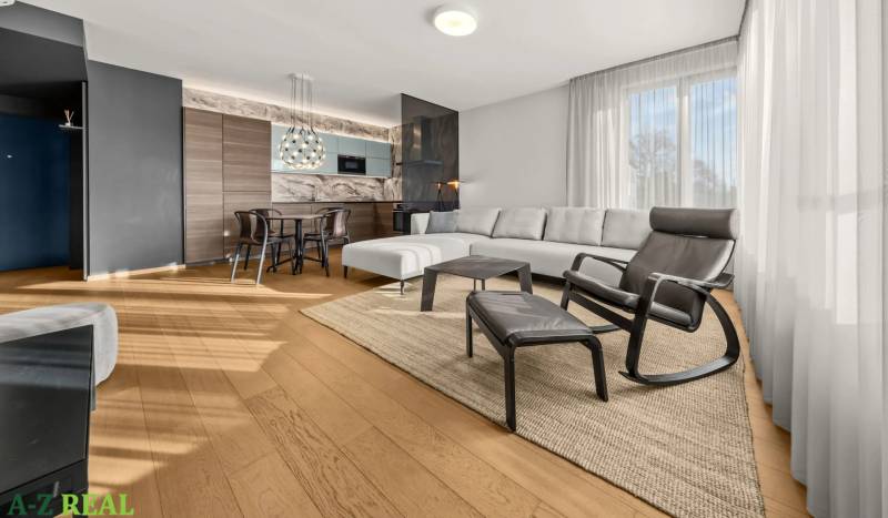 Living room in a two-room apartment with a wooden decor floor and a sofa.