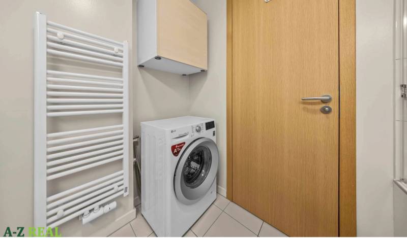 Bathroom with a washing machine and a radiator in a 2-room apartment.