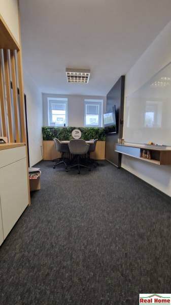 Offices with a conference table, comfortable chairs, and a green wall.