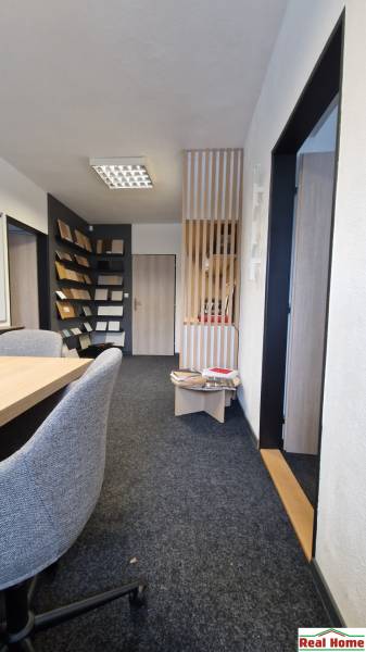 Offices with cream carpet, wooden panels, and material samples on the walls.