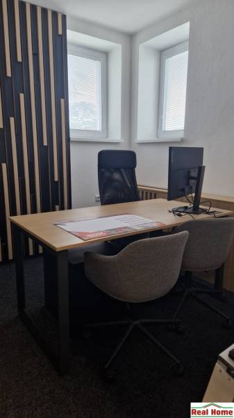 Offices with a desk, swivel chair, and textured wall.