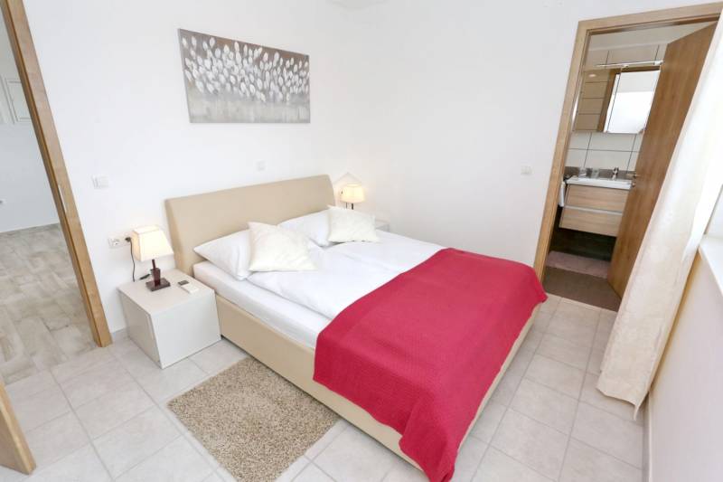 A bedroom in a 3-room apartment with a double bed and light decorations.