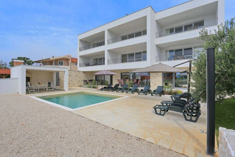 Apartment complex with a pool and terrace in the town of Sukošan, ideal for relaxation.