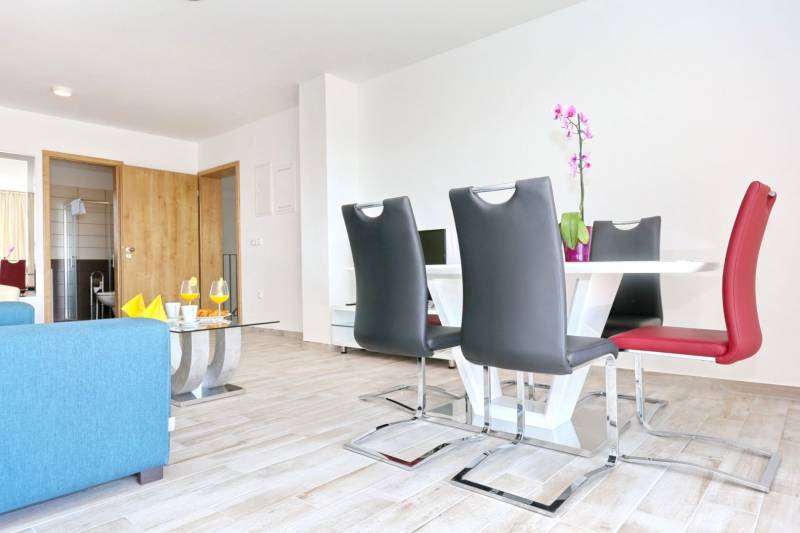 A bright dining room with fresh decor and a wood-patterned floor in a 3-room apartment.