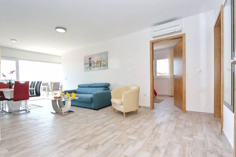 A bright interior of a 3-room apartment with a wooden decor floor and comfortable seating.
