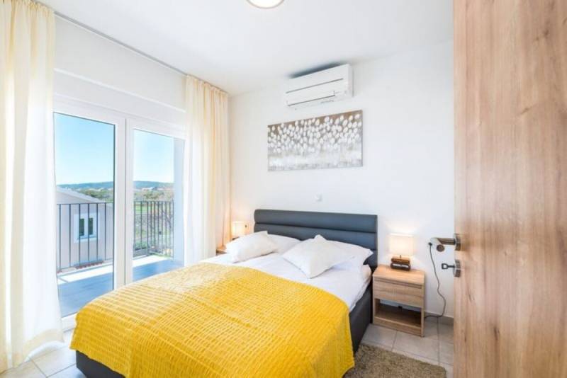 A bedroom in a 3-room apartment with a bed, a balcony, and a bright interior.