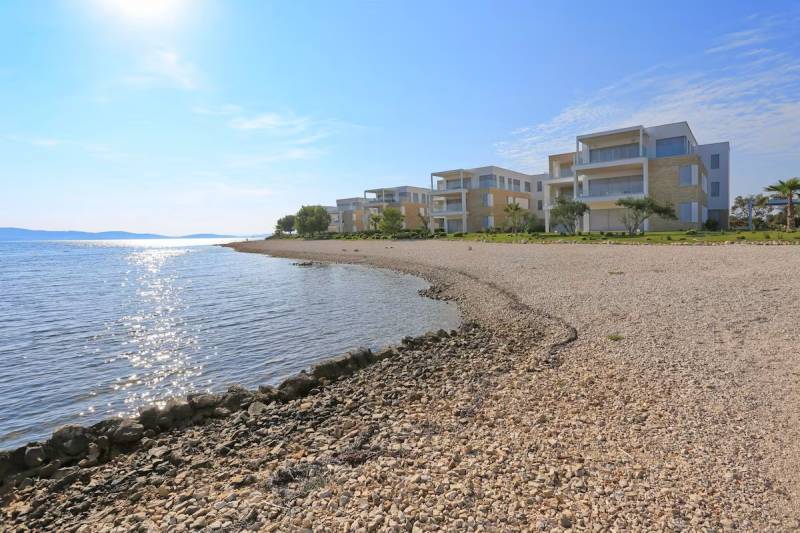 A view of the coast with buildings and the sea in Sukošan, ideal for relaxation.