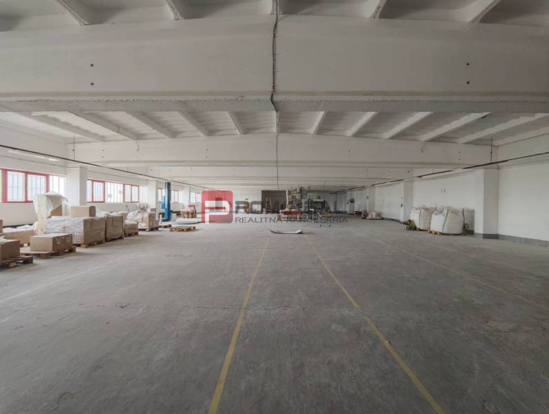 A production area with a concrete floor, equipment stored on pallets.